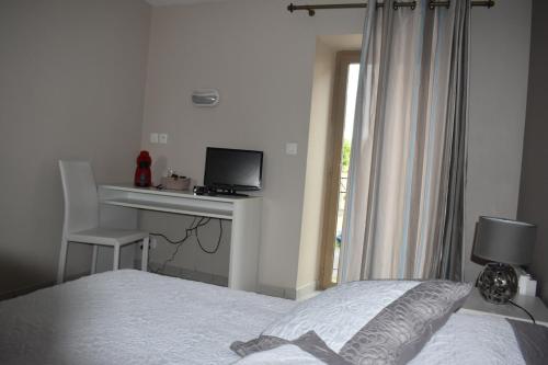 a bedroom with a bed and a desk with a computer at Carpe Diem 2 in Goutrens