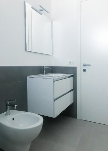 a white bathroom with a sink and a mirror at Alba B&B in Cattolica