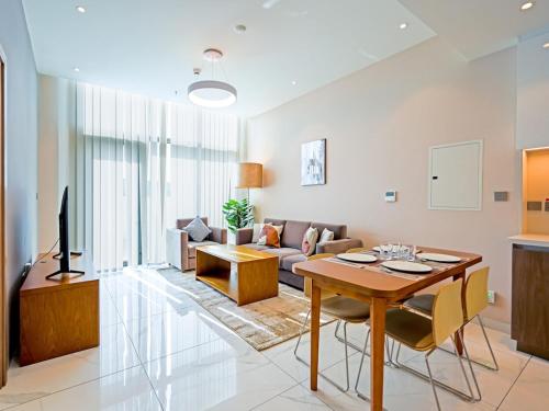 a living room with a table and a couch at Elegant 1-Bedroom Apartment in Al Furjan-710 in Dubai