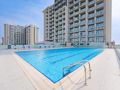 a large swimming pool in front of a building at Elegant 1-Bedroom Apartment in Al Furjan-710 in Dubai