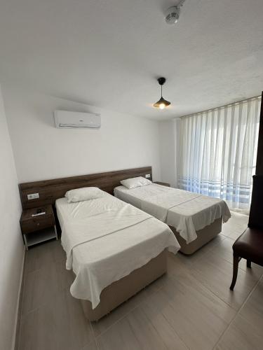 a hotel room with two beds and a window at Akmonya Pansiyon in Eriklice