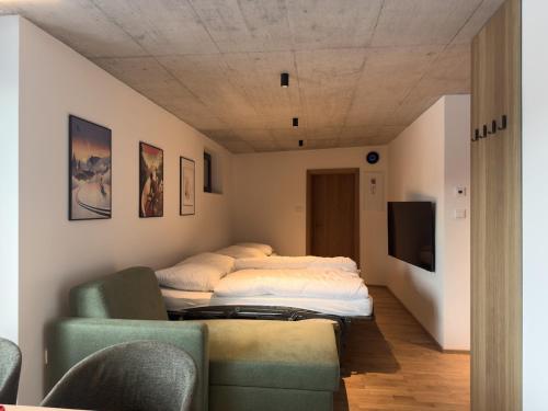 two beds in a room with a couch and a tv at Apartmán Ore&Moor in Boží Dar