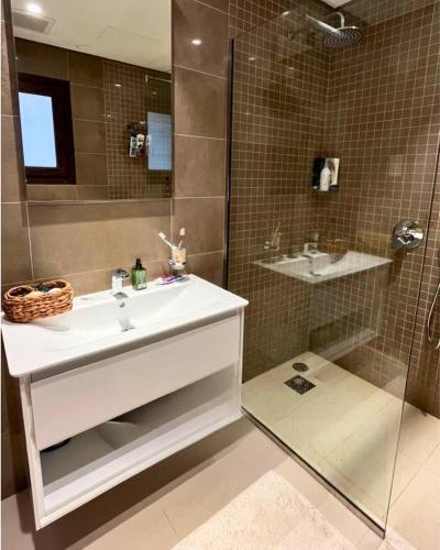 a bathroom with a sink and a shower at Sifa Golf & Beach Escape in As Sīfah