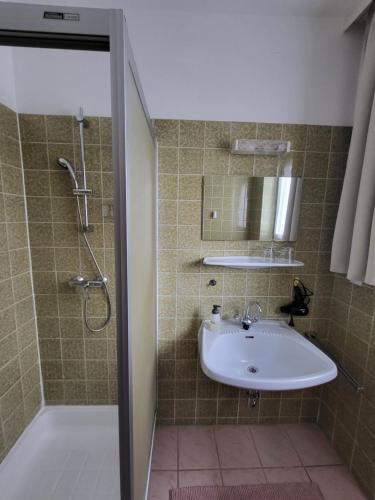 a bathroom with a sink and a shower at Privatzimmer Haus Lienbacher in Mittersill