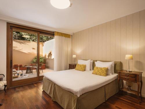a bedroom with a large bed with yellow pillows at SK Place Luxury Seafront Villas Chania in Almyrida