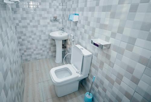 a bathroom with a toilet and a sink at Cityscape And Retreat Hotel in Mbeya