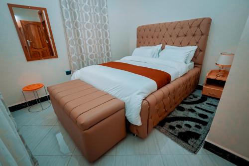 a large bed with a brown leather headboard in a room at Cityscape And Retreat Hotel in Mbeya