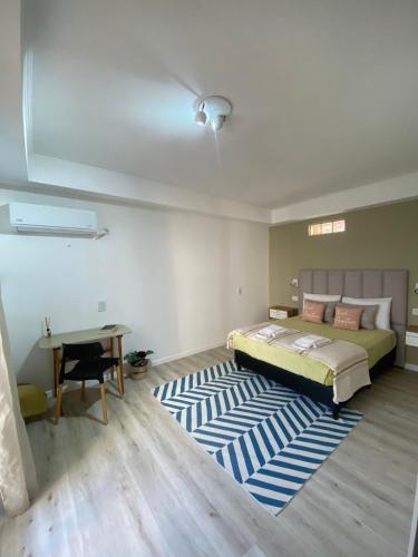 a bedroom with a bed and a desk and a rug at Estudio Villa Rosas in Rafaela