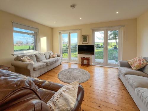 a living room with two couches and a television at Holly Croft in Drem