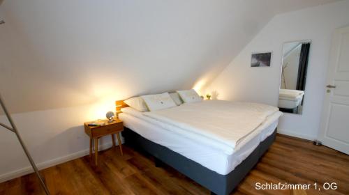 a bedroom with a bed and a night stand with a lamp at Ferienhaus Sonne in Göhren-Lebbin