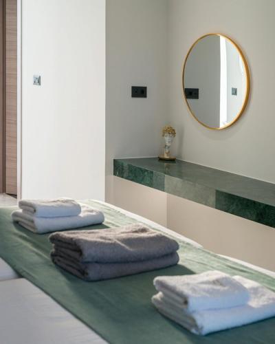a bathroom with three towels on a counter with a mirror at Palme Luxury Villa in Galatás