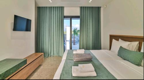 a bedroom with a large bed with green curtains at Palme Luxury Villa in Galatás