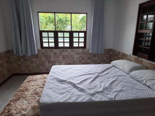 a large bed in a room with a window at Suíte Tranquila em Ambiente Familiar em Antares in Maceió