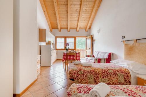 a room with two beds and a kitchen with a table at Sarca Lodge Val Rendena in Dare