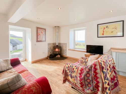 a living room with a couch and a fireplace at The Cheese Loft in Drummore
