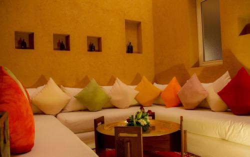 a living room with a white couch with colorful pillows at Berbère Palace in Ouarzazate