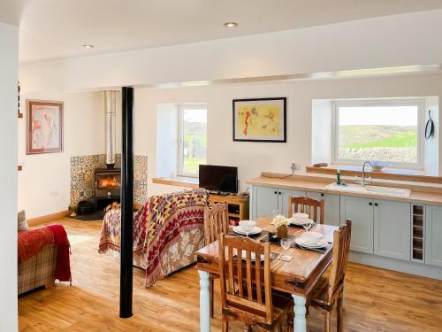 a kitchen and living room with a table and a couch at The Cheese Loft in Drummore