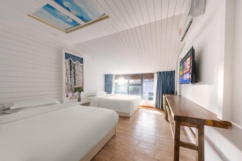 a bedroom with a bed and a desk and a tv at YISHUYIHUACoFFee Hotel in Zhangjiajie