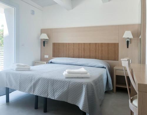a bedroom with a bed with towels on it at Alba B&B in Cattolica