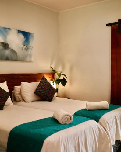 a bedroom with two beds with towels on them at Jollyboys Backpackers and Camp in Livingstone