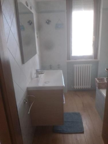 a bathroom with a white sink and a window at Casa Di Leonardo in Loreto
