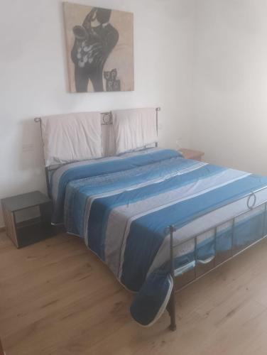 a bed with a blue comforter in a bedroom at Casa Di Leonardo in Loreto