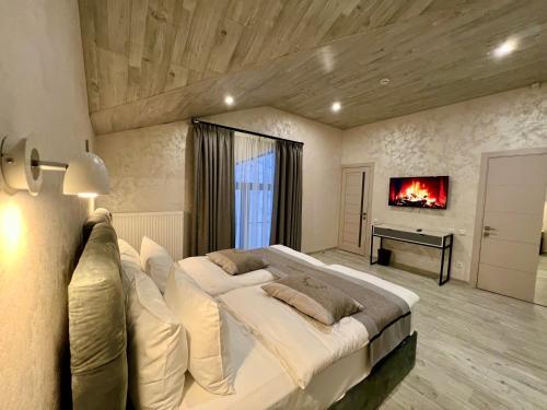 a large bedroom with a large bed with a fireplace at PANORAMA Chalet MOUNTAIN RESIDENCE in Bukovel