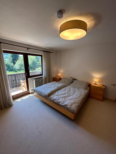 a bedroom with a bed and a large window at Gemütliche Ferienwohnung mit Blick ins Grüne in Zwiesel