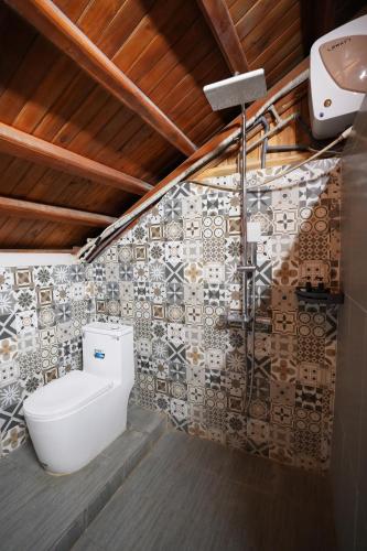 a bathroom with a toilet and a shower at Woodstock Beach Camp in Cat Ba