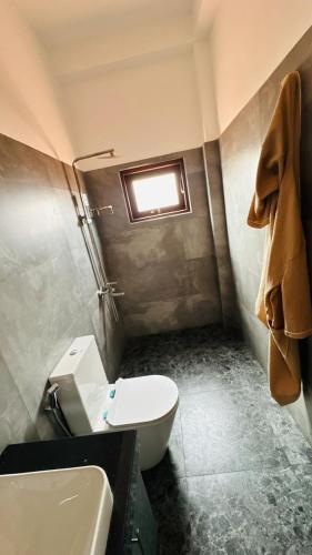 a bathroom with a sink and a toilet and a window at Jameens Residence in Ambalangoda