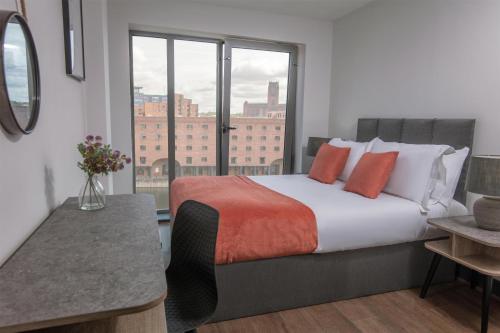 a bedroom with a large bed with a large window at Dockside Aparthotel, Best Western Signature Collection in Liverpool