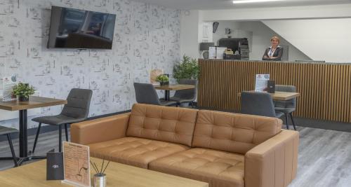 a woman standing at the counter of a waiting room at Dockside Aparthotel, Best Western Signature Collection in Liverpool