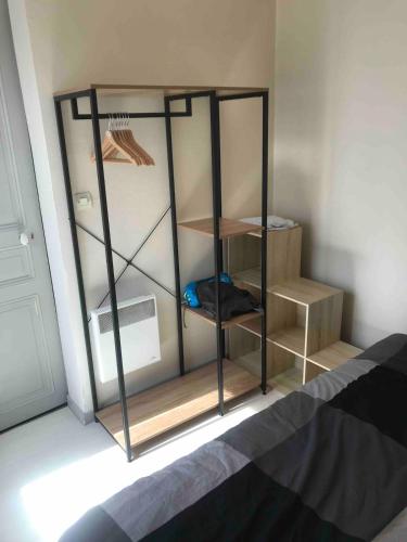 Appartement hyper centre في رانس: غرفة بها غرفة بها رف وسرير