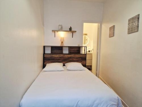 een kleine slaapkamer met een bed en twee witte kussens bij Frégate in Cherbourg en Cotentin