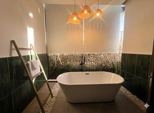 una vasca da bagno in un bagno con piastrelle verdi di Somnea Villa a Kampot