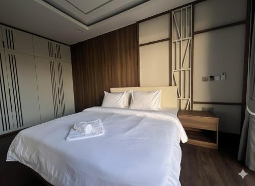 una camera da letto con un letto bianco con un asciugamano sopra di Somnea Villa a Kampot