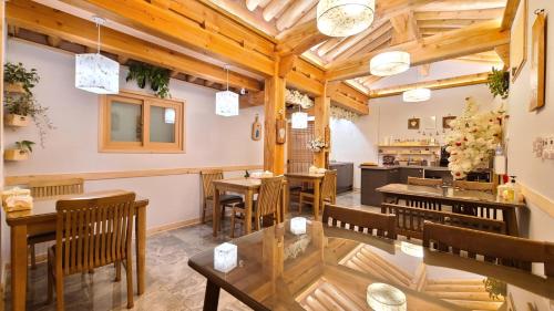 a restaurant with wooden ceilings and tables and chairs at 나들한옥 한옥스테이 in Gyeongju