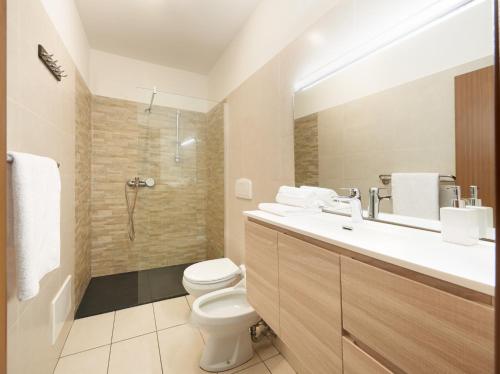 a bathroom with a toilet and a sink and a shower at Central Palm Studio with free Parking in Merano