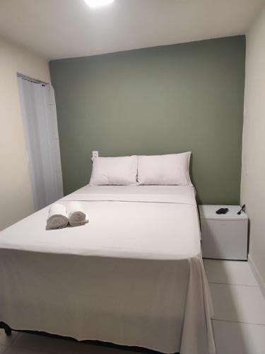 a white bed with two hats on top of it at Pousada Oxente Carioca in João Pessoa