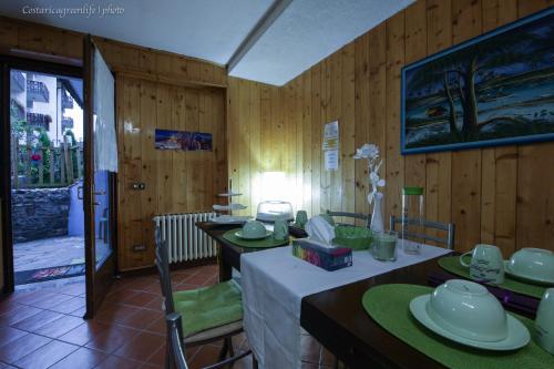 a dining room with wooden walls and tables with green chairs at Central Greenlife in Tarvisio