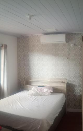 a bedroom with a bed with a white bedsheet at 500 metros da praia in Governador Celso Ramos
