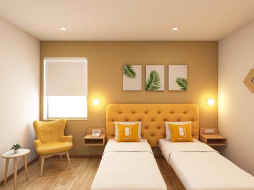 a bedroom with two beds and a yellow chair at Bloom Hotel - ISKCON Rajajinagar in Bangalore