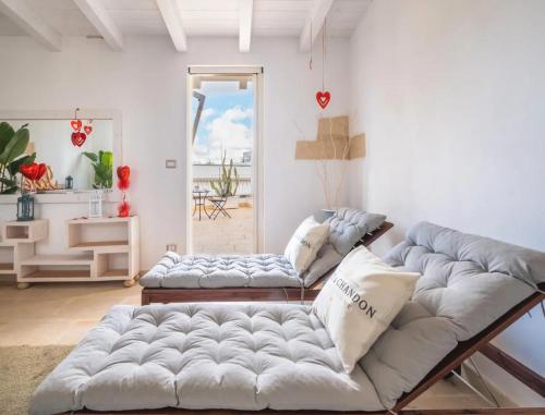 a living room with two couches and a window at Corte Aragonese Suite Spa Privata in Veglie