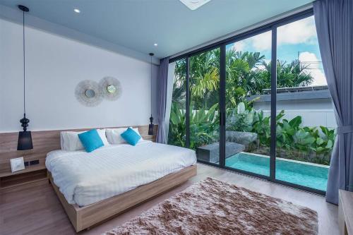 a bedroom with a bed and a large window at Stylish 2BR Naiton Aileen Villa w Private Pool in Nai Thon Beach