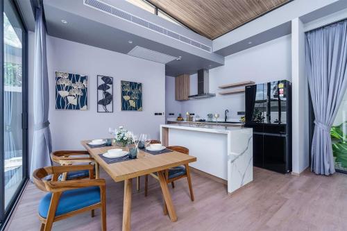 a kitchen and dining room with a table and chairs at Stylish 2BR Naiton Aileen Villa w Private Pool in Nai Thon Beach