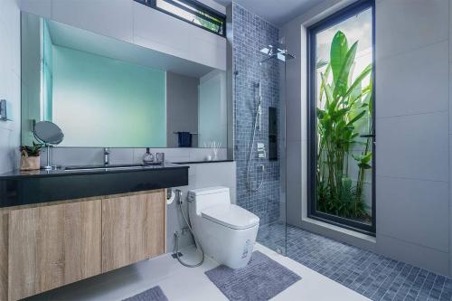 a bathroom with a toilet and a sink with a plant at Stylish 2BR Naiton Aileen Villa w Private Pool in Nai Thon Beach