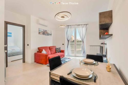 a living room with a table and a red couch at Cà del Magra, TerreMarine in Santo Stefano di Magra