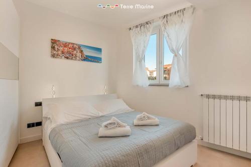 a bedroom with a bed with two towels on it at Cà del Magra, TerreMarine in Santo Stefano di Magra