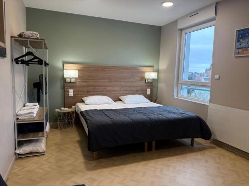 a bedroom with a bed and a window at Hotel de la Terrasse in Berck-sur-Mer