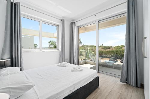 a bedroom with a bed and a large window at Levanda Hills Haven in Protaras in Paralimni